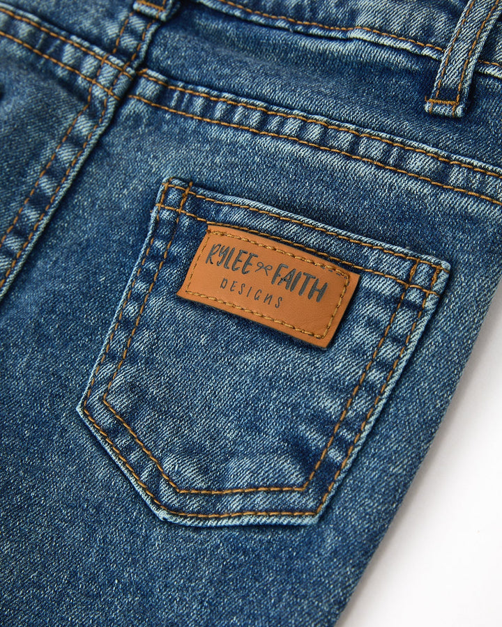 Denim jeans with leather brand patch on back pocket