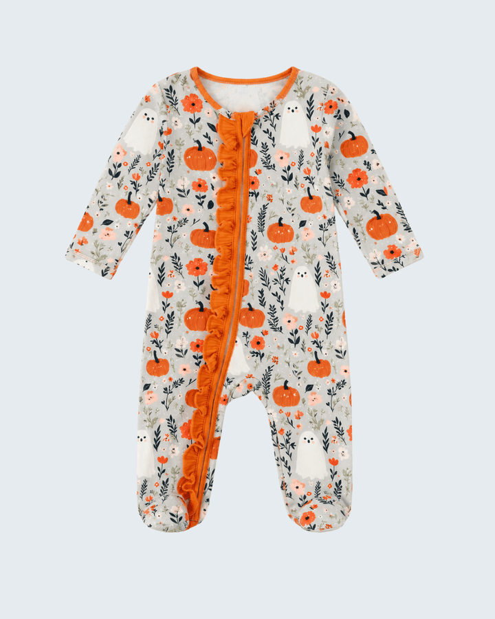 A baby footed sleeper with a long-sleeve design, featuring an orange ruffle down the front zipper, an orange crew neck trim, and an all-over print of orange pumpkins, white ghosts, and gray leaves on a cream background.