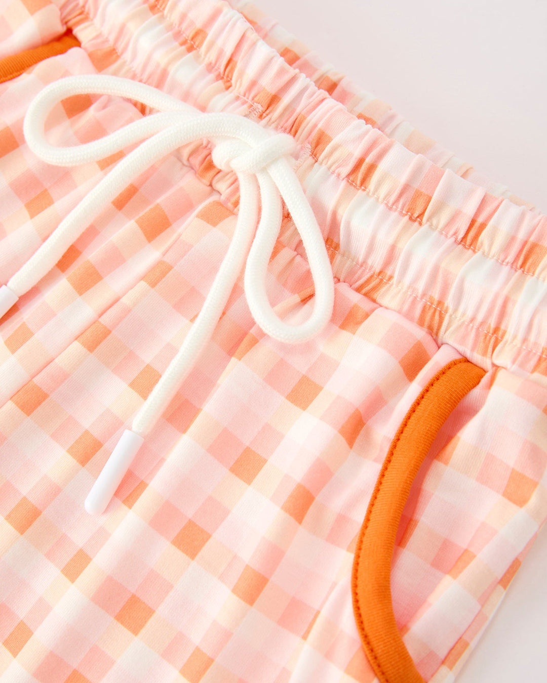 Pink plaid drawstring waist pants with orange trim and gathered waistband
