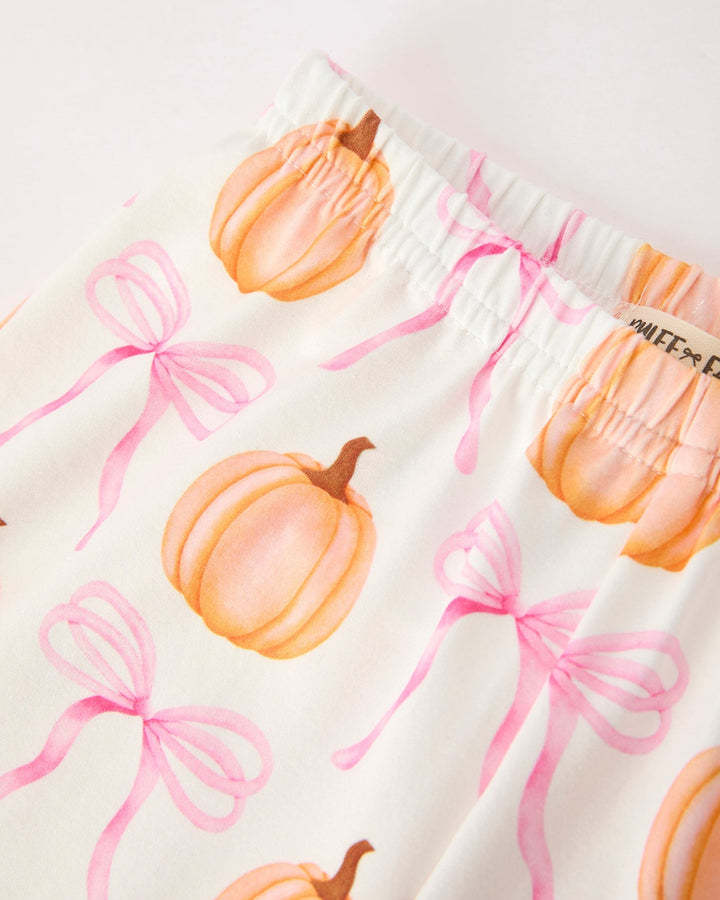 White pajama fabric with orange pumpkins and pink ribbon bow print