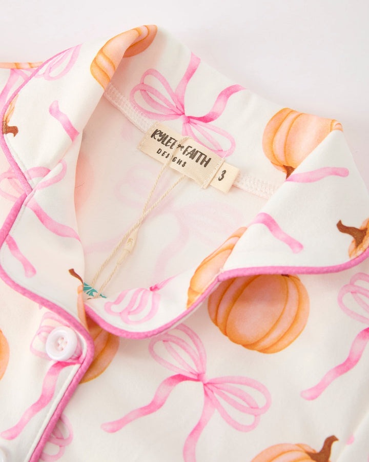 Zip-front pajama top with pink trim and partial brand tag at collar