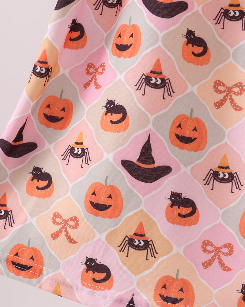 Close-up of Halloween print fabric with pumpkins and spiders on light pink background