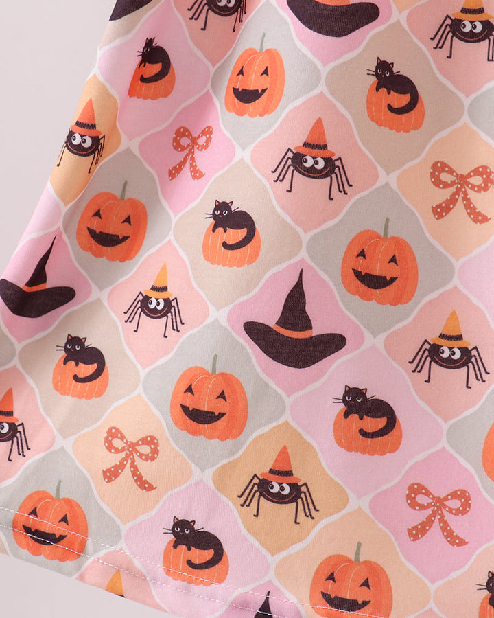 Close-up of Halloween print fabric with pumpkins and spiders on light pink background