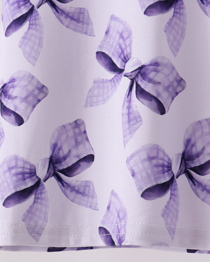 Bow-print bamboo pajama top hem detail in purple on light fabric