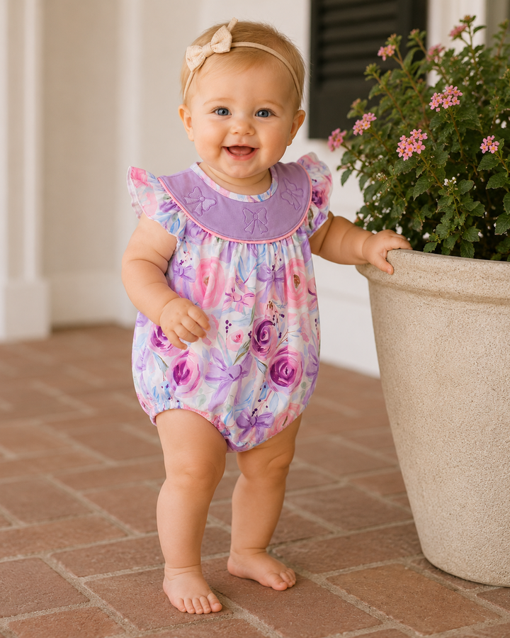 Baby girl standing by flower pot.