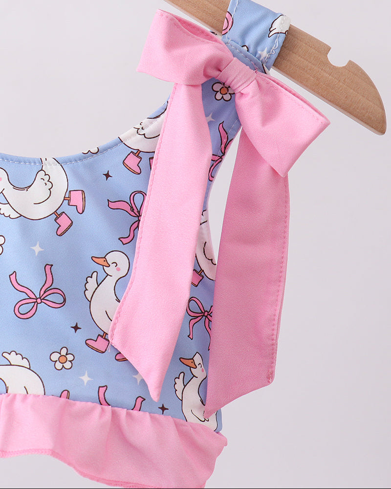 Swim top with pink bow and duck pattern on a hanger