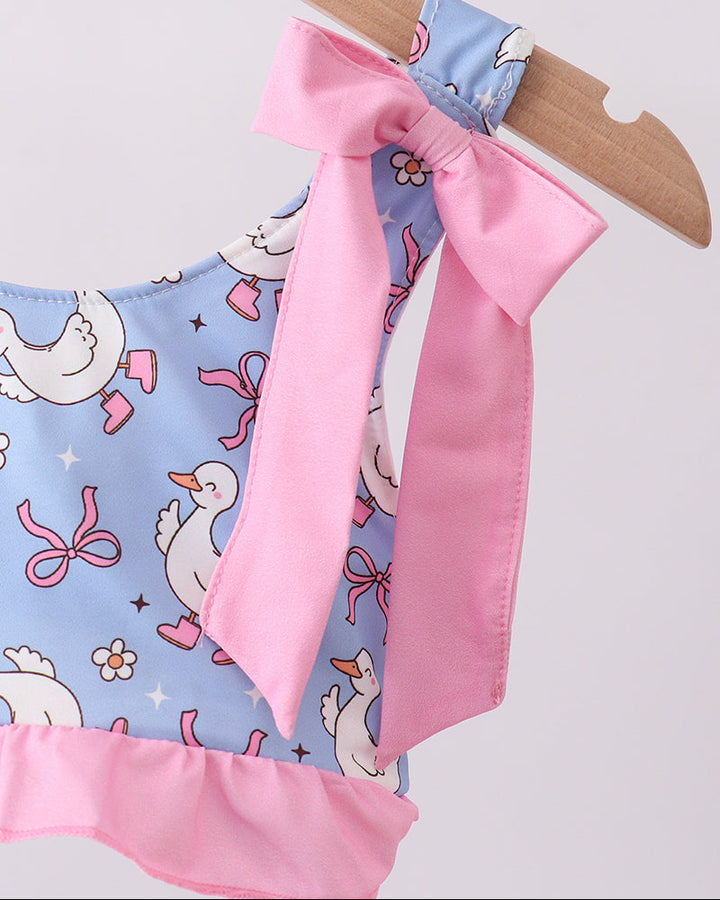 Swim top with pink bow and duck pattern on a hanger