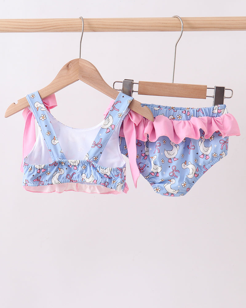 Swimwear set with pink ruffles on a wooden hanger against a white background