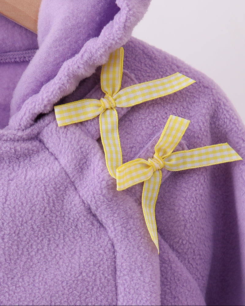 Purple fleece hooded coat with two yellow gingham bow accents on the chest