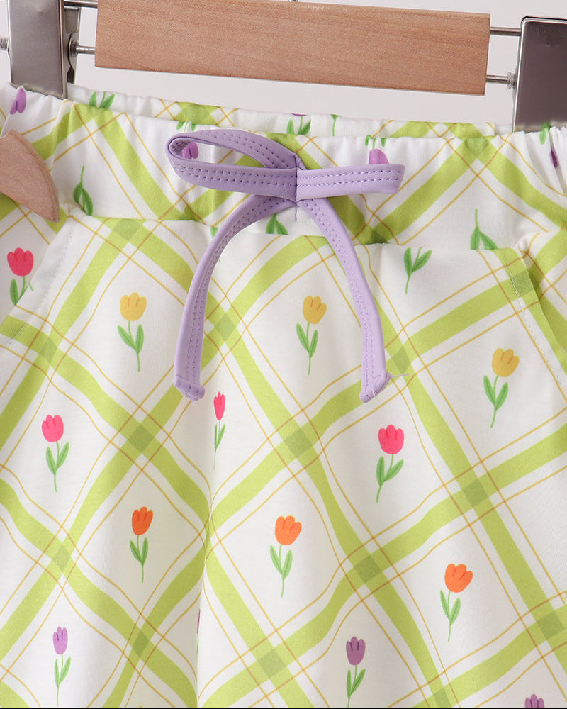 Floral-patterned skort with a purple tie on a hanger against a white background
