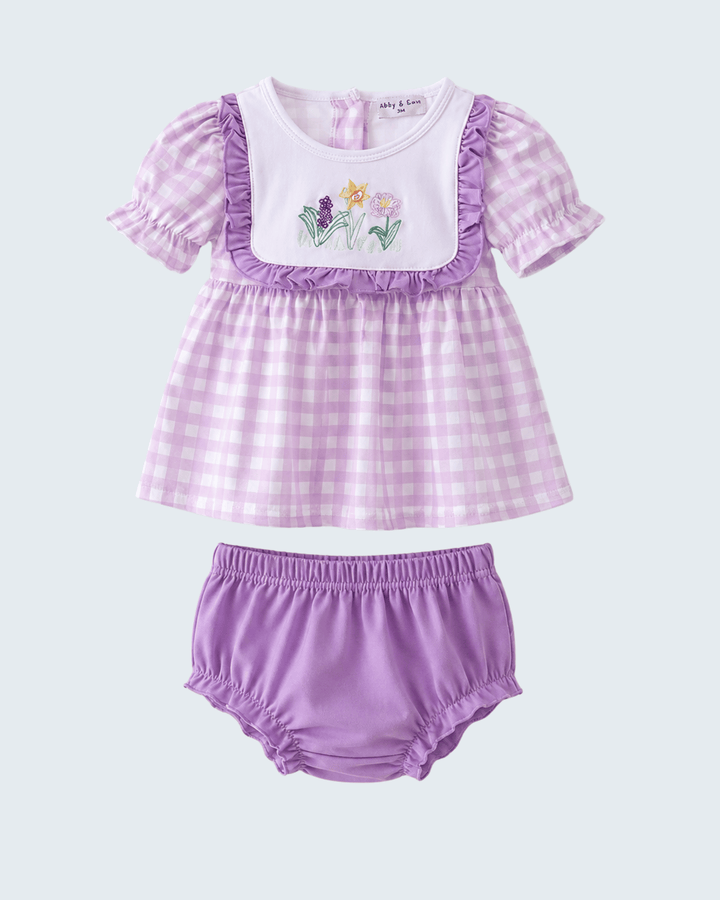 Baby outfit with checkered top and bloomers on a light gray background