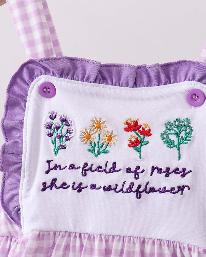 Close up of embroidered flowers on purple gingham dress