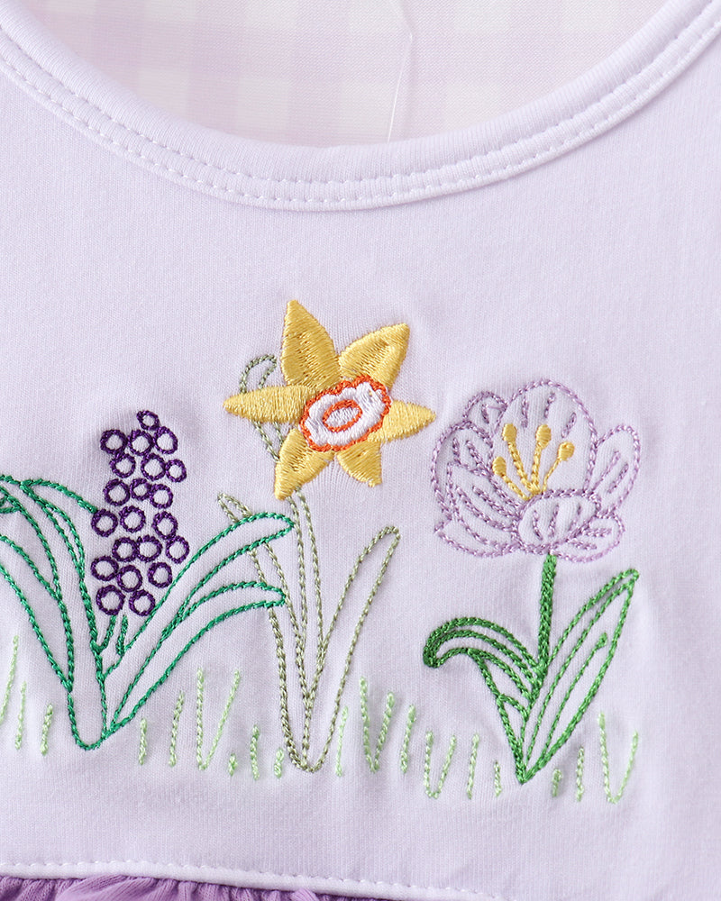 Embroidered floral design on a white and purple fabric