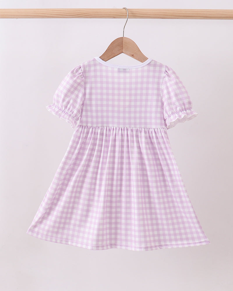 Pink and white checkered dress on a hanger against a white background
