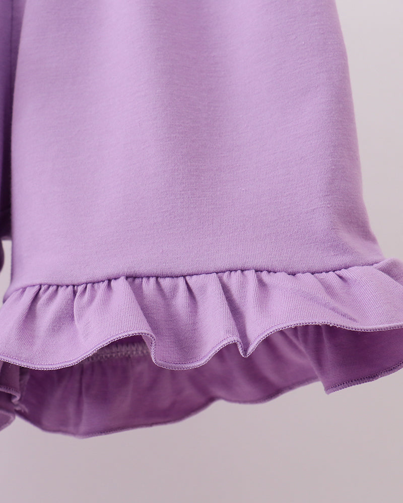 Close-up of a purple shorts with ruffled hem on a light gray background