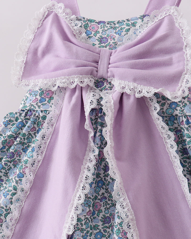 Close up of large purple bow on floral fabric
