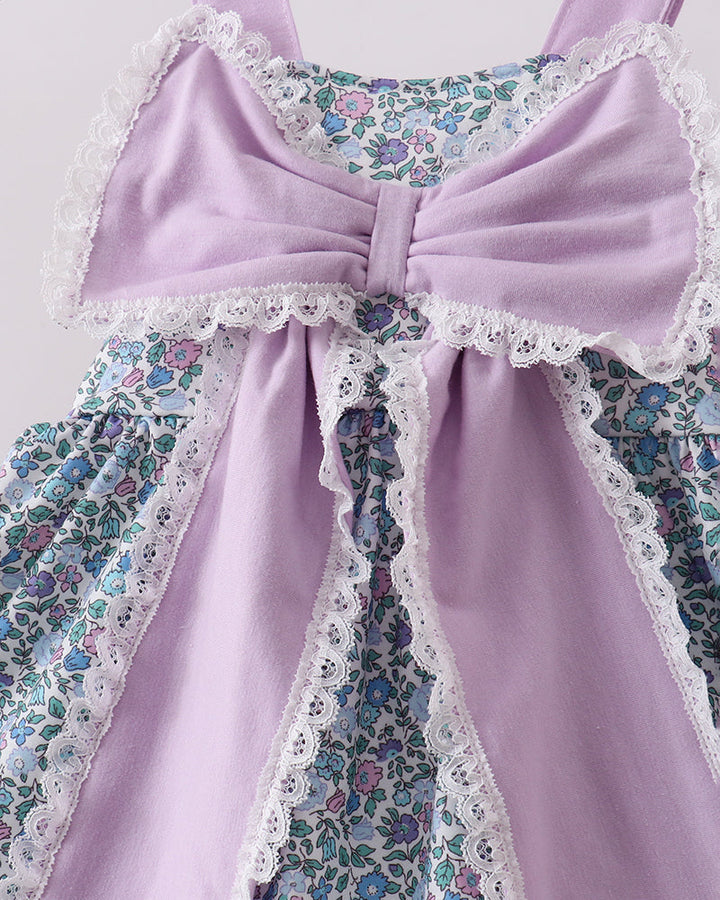 Close up of large purple bow on floral fabric