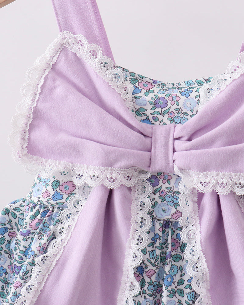 Close up of large purple bow on floral dress