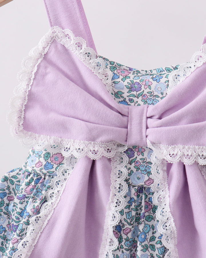 Close up of large purple bow on floral dress