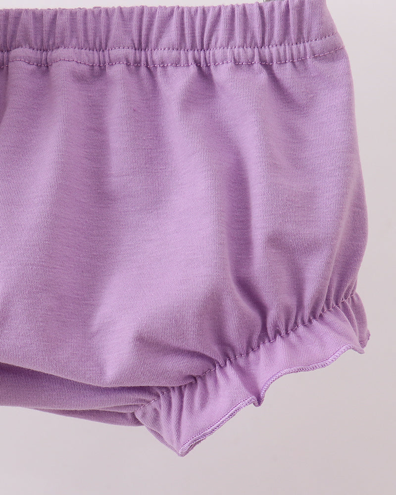 Purple baby bloomers on a light gray background