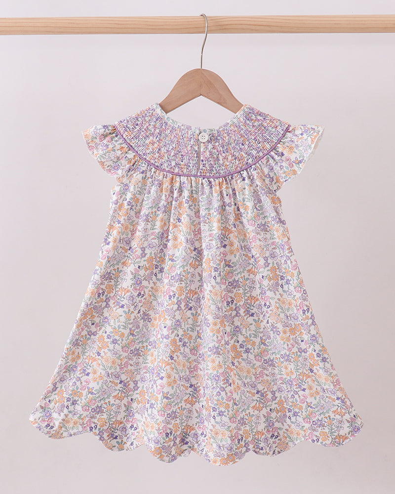 Floral dress on a hanger against a plain background