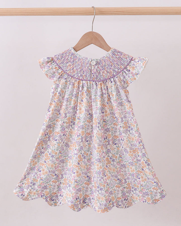 Floral dress on a hanger against a plain background