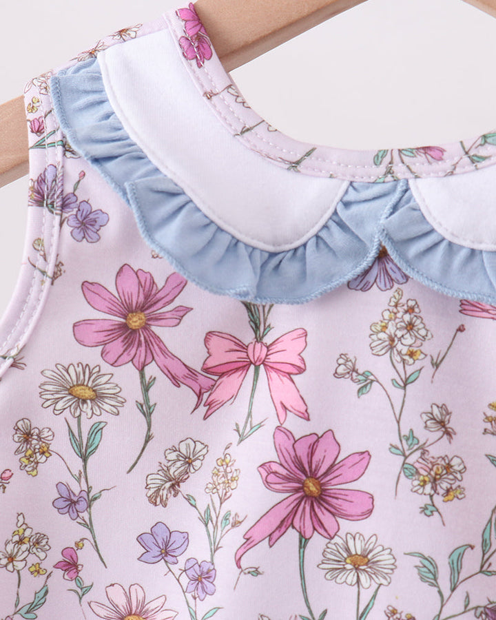 Close-up of a floral-patterned dress with ruffled collar and sleeves.