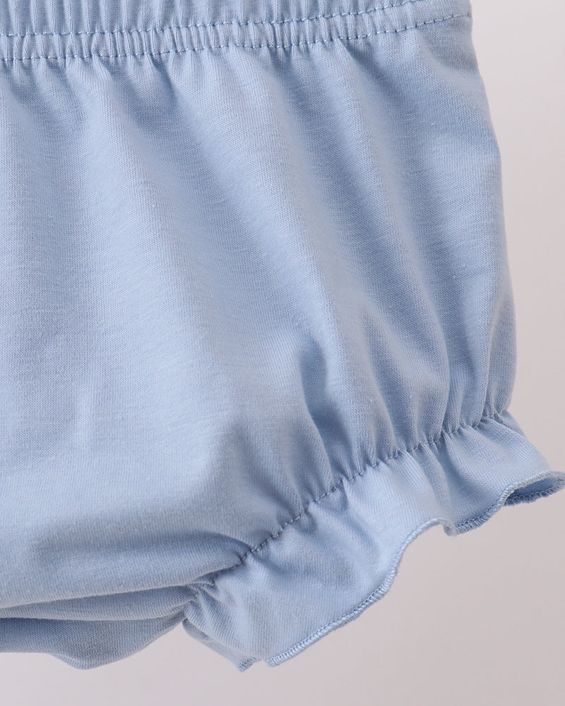 Light blue baby bloomers on a beige background