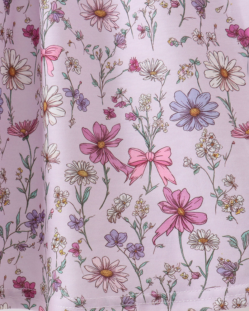 Floral patterned fabric with pink flowers and bows on a light purple background