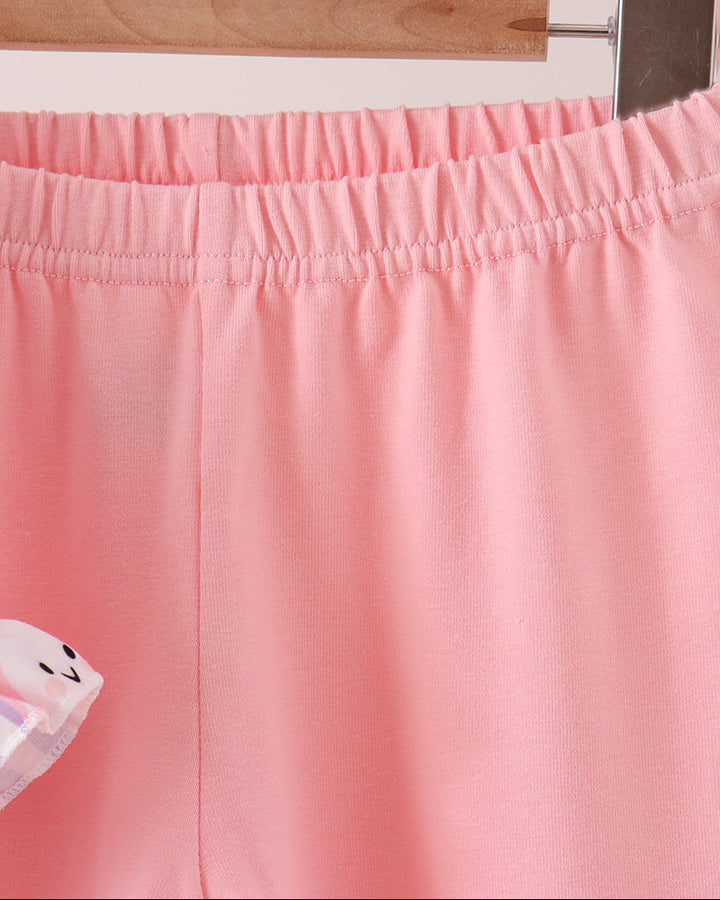 A close-up of a pair of light pink pants  hanging on a wooden hanger, showing the elastic waistband and smooth fabric texture.