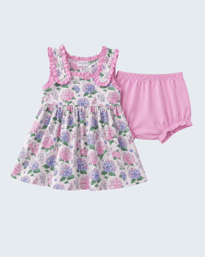 Floral dress with ruffled straps and pink bloomers on a light gray background