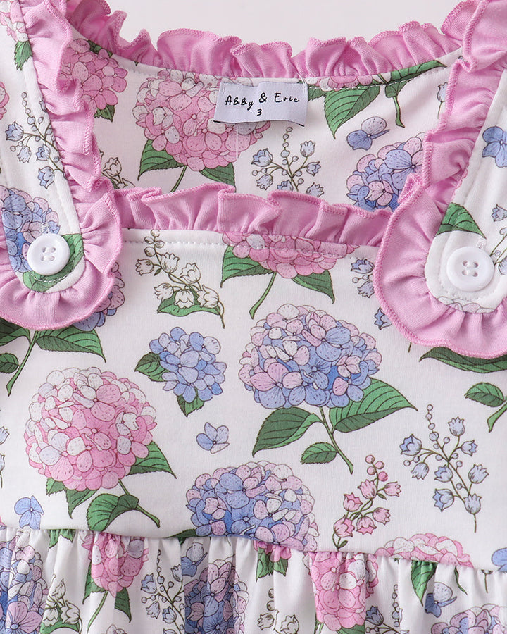 Floral baby blanket with pink ruffles and buttons on a white background
