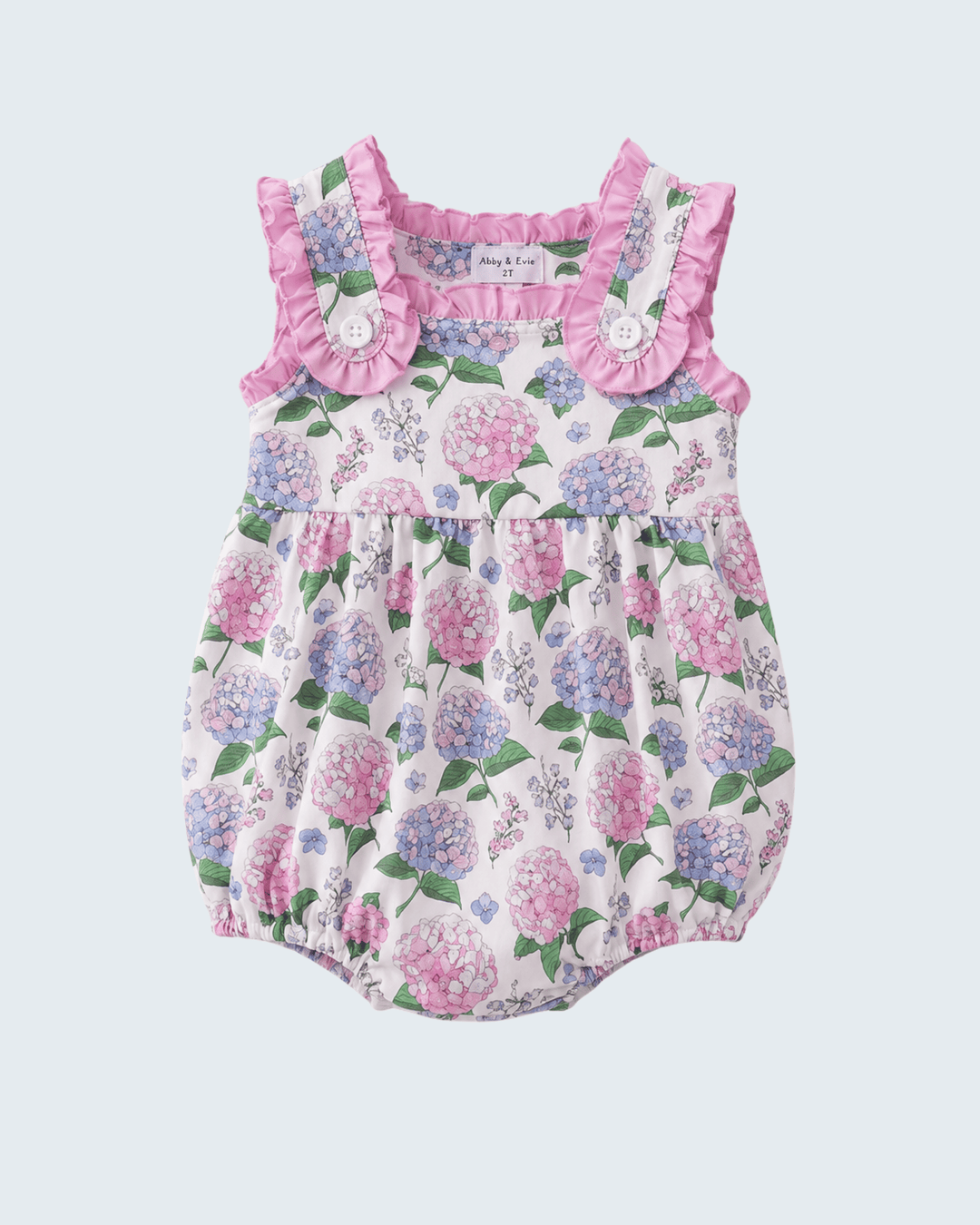 Floral baby romper with ruffled neckline on a light purple background