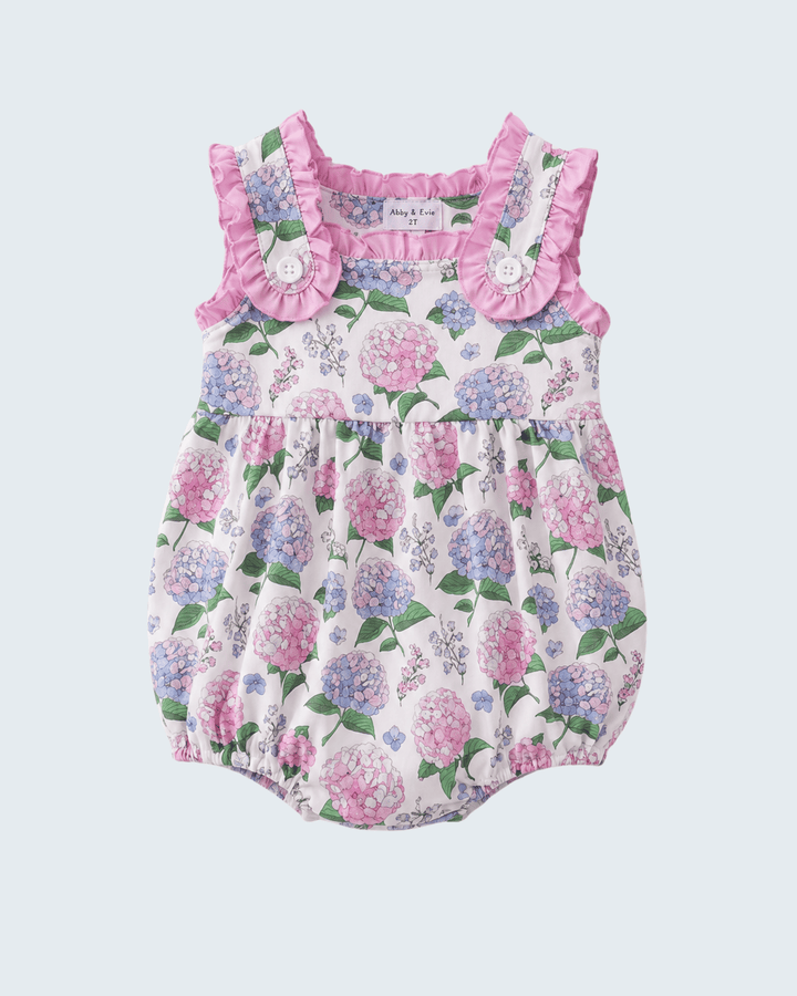 Floral baby romper with ruffled neckline on a light purple background