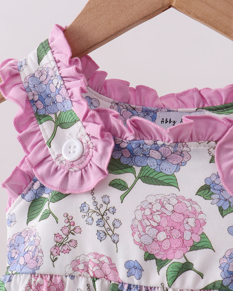 Floral romper with ruffled details on a hanger