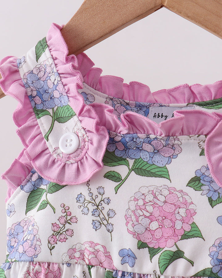 Floral romper with ruffled details on a hanger