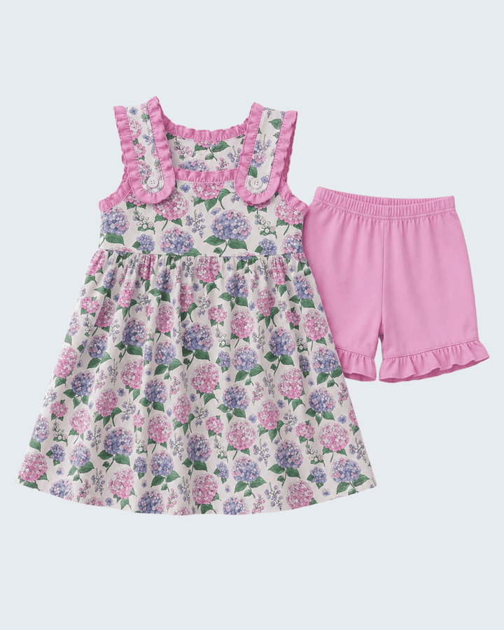 Floral dress and pink shorts set on a light purple background