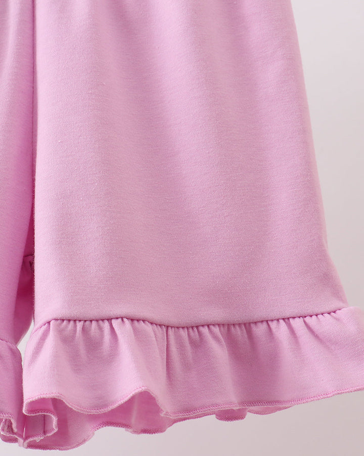 Close-up of a pink shorts with ruffled hem on a light background