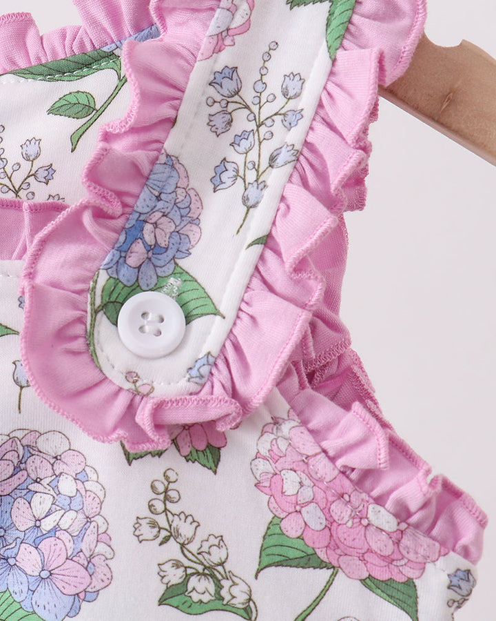 Floral fabric with pink ruffles and a button on a white background