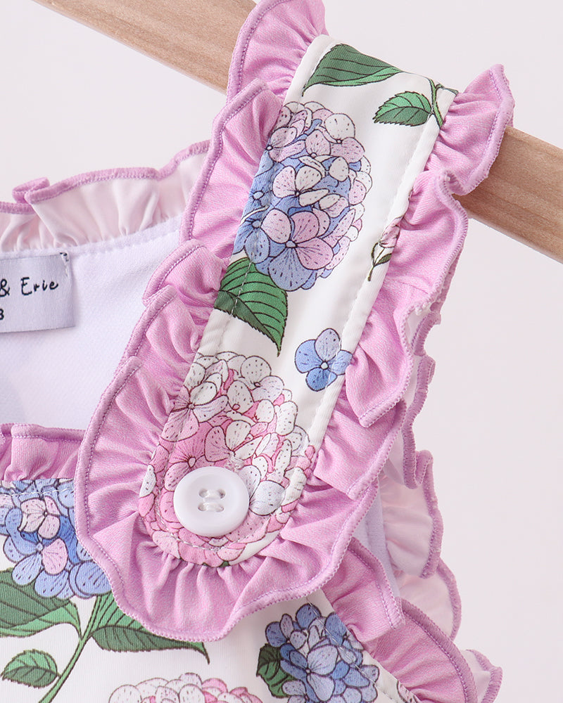 Floral baby romper with ruffled details on a white background
