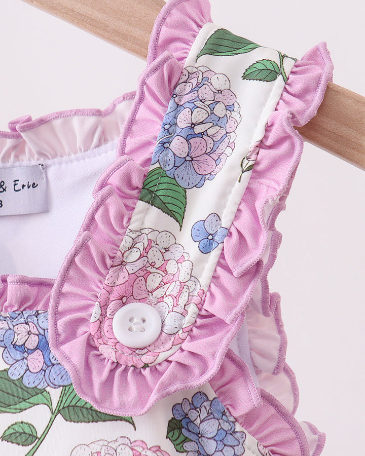 Floral baby romper with ruffled details on a white background