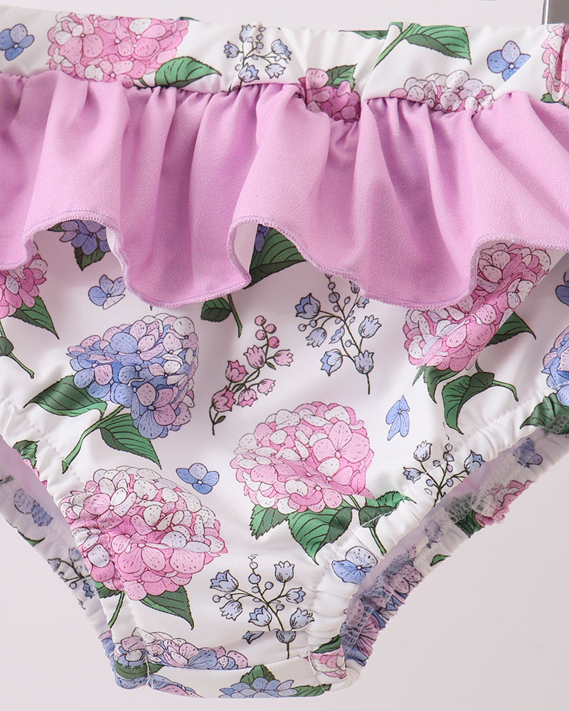 Floral-patterned swimsuit with a pink ruffled waistband on a white background