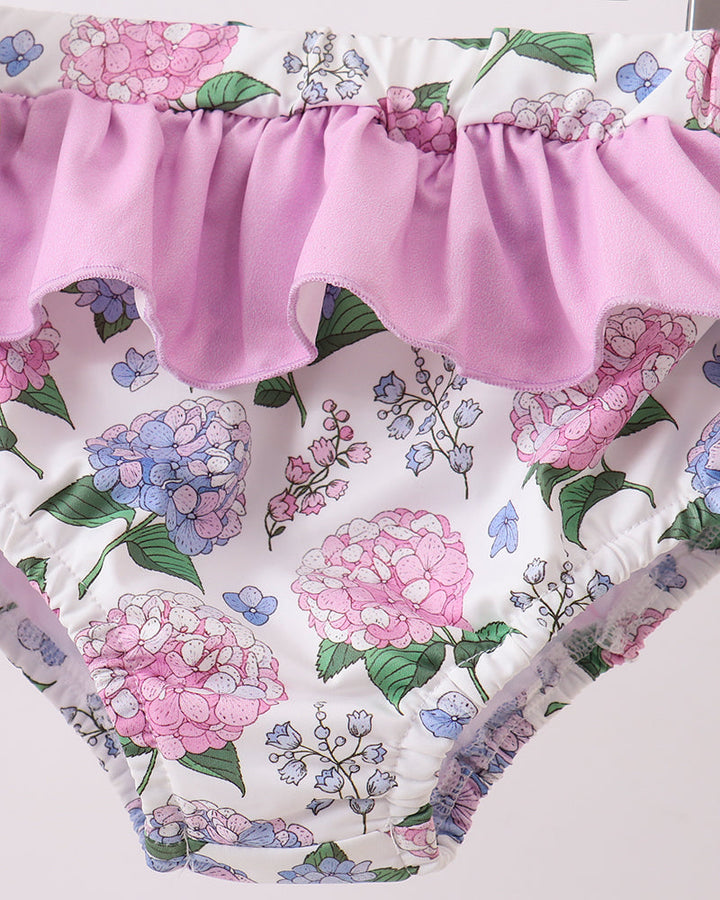 Floral-patterned swimsuit with a pink ruffled waistband on a white background
