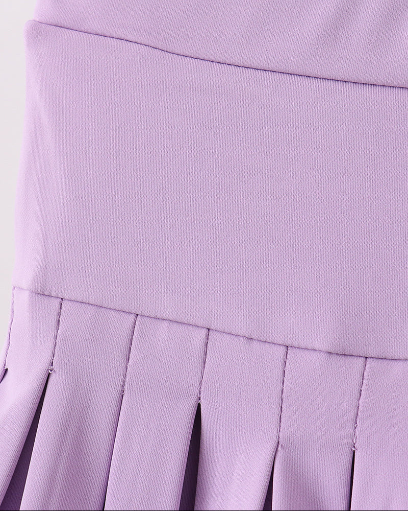 Close-up of a purple pleated skirt on a white background
