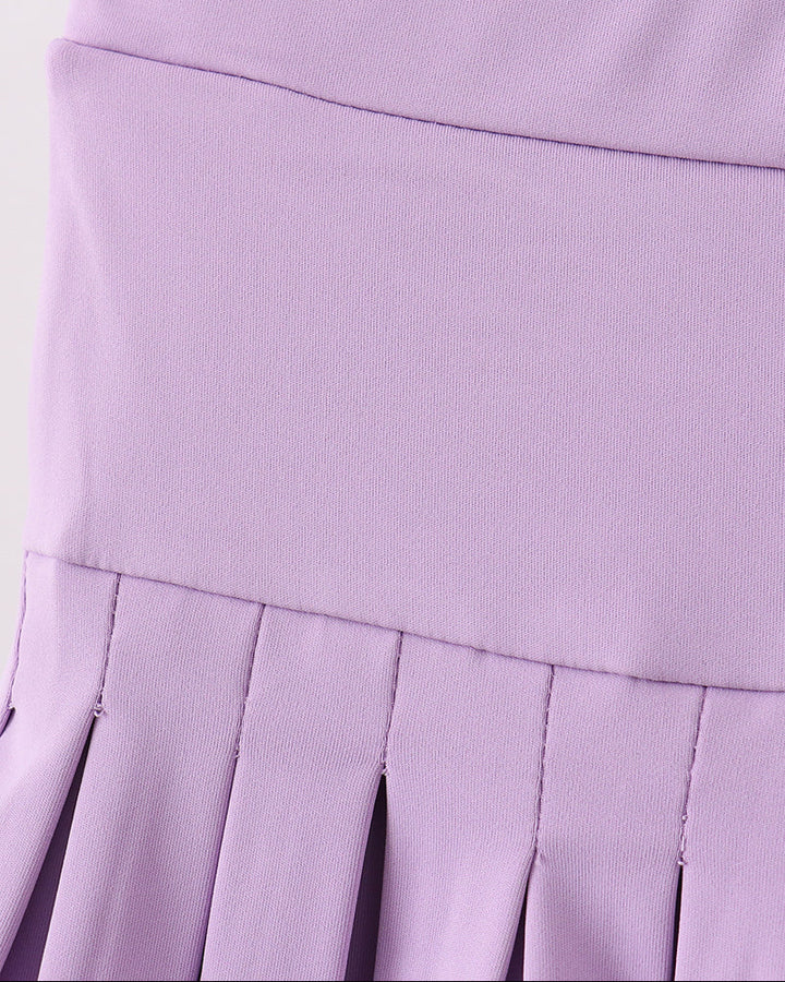 Close-up of a purple pleated skirt on a white background