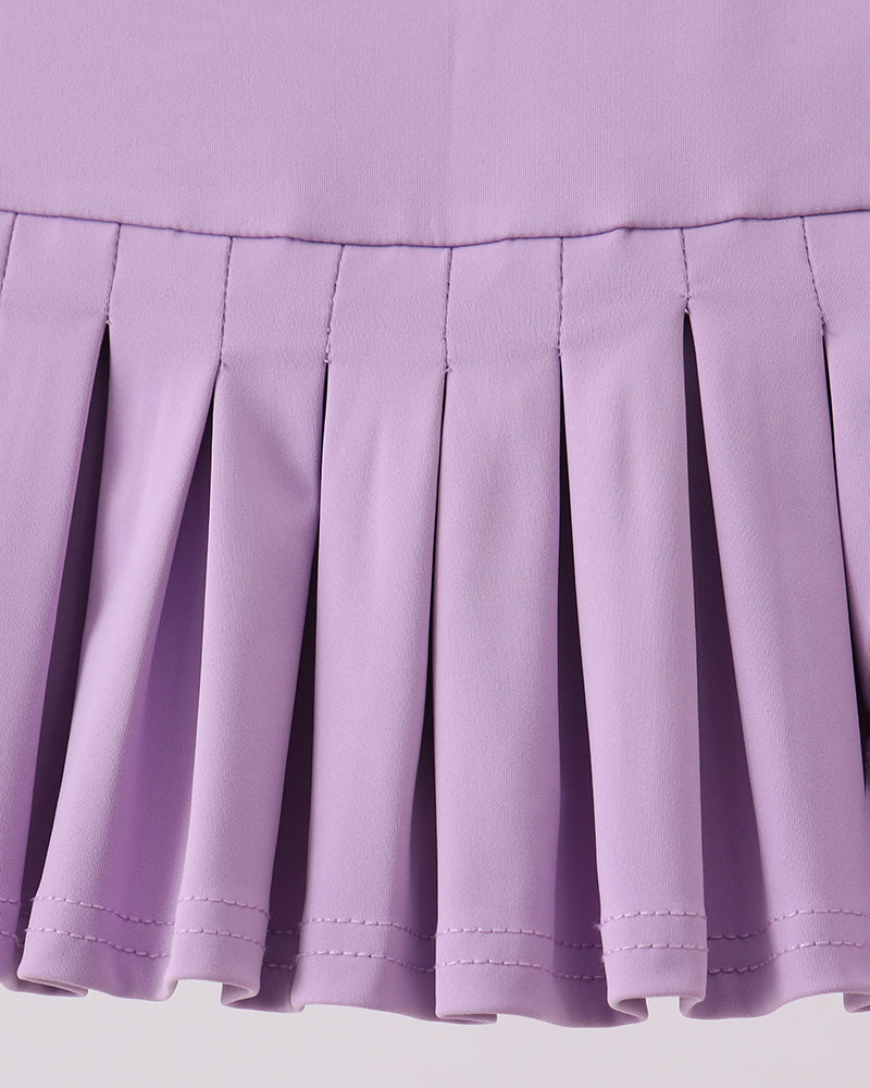 Close-up of a pleated purple skirt on a light gray background