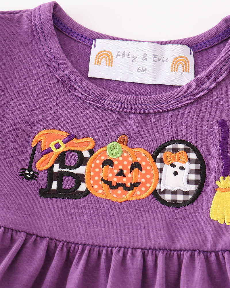 Close-up of purple dress top with pumpkin ghost applique and neck label