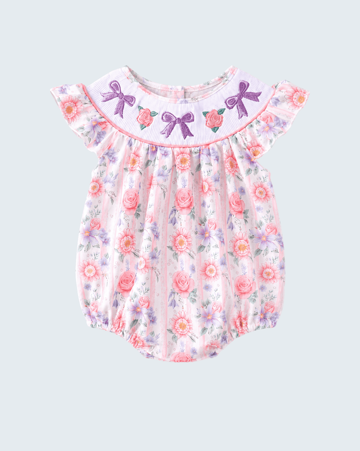 Floral baby romper with bow details on a light gray background