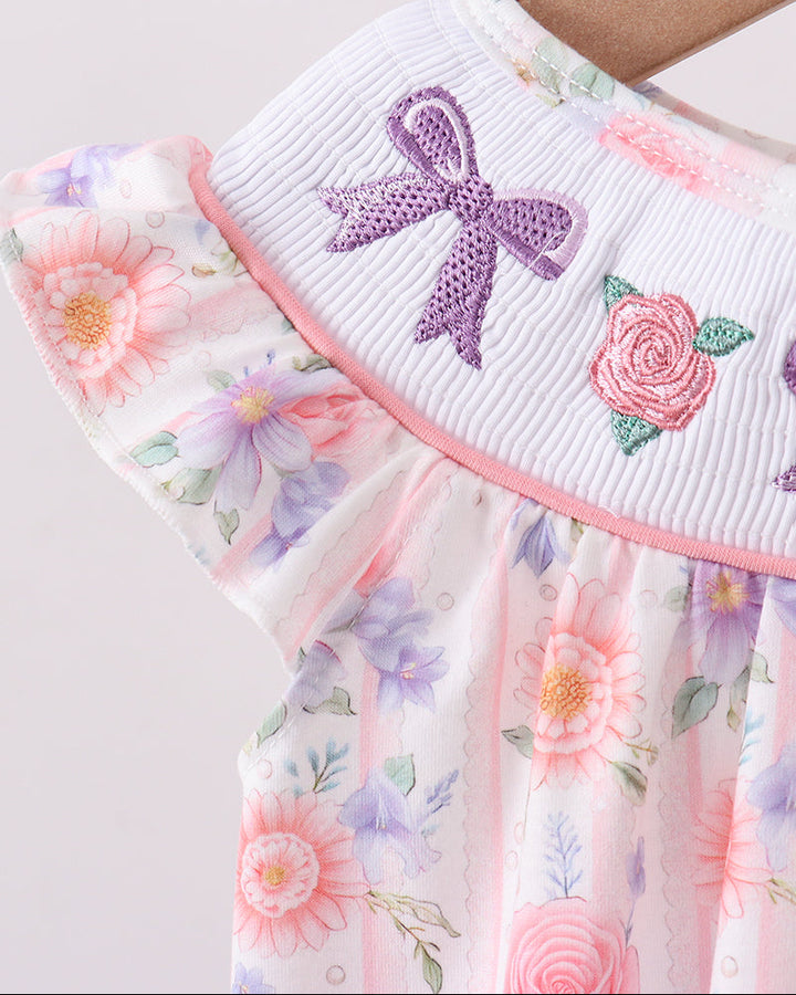 Floral dress with a purple bow detail on a plain background