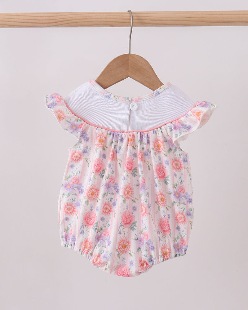 Floral baby romper with white collar on a wooden hanger against a light gray background
